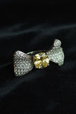 Silver bow-shaped ring with a yellow gemstone