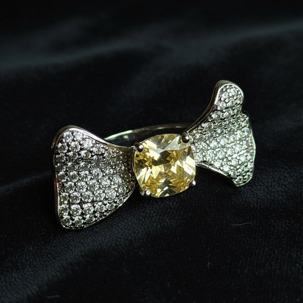 Silver bow-shaped ring with a yellow gemstone
