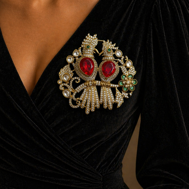 Close-up of a black dress with a large, ornate brooch 