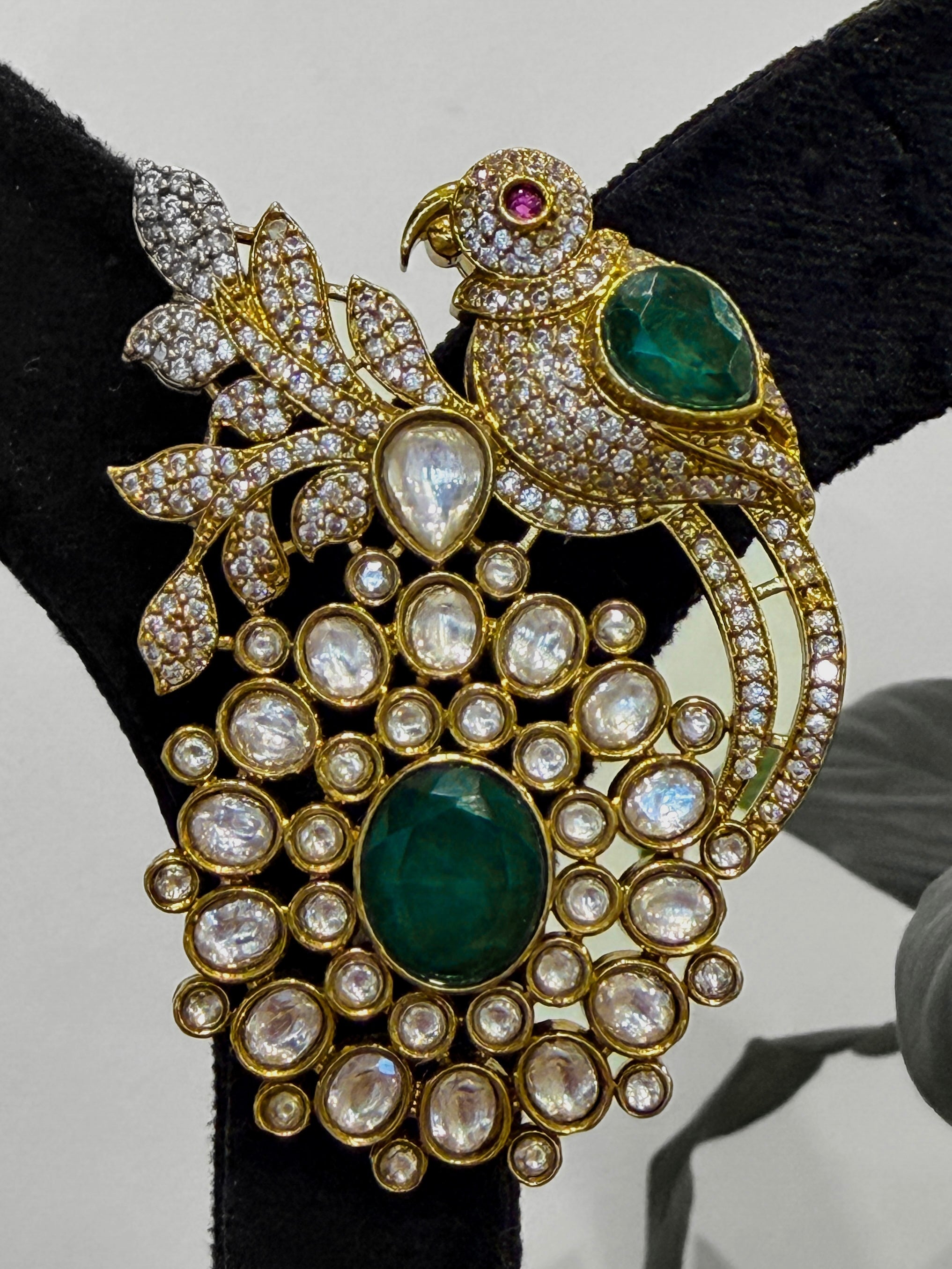 Ornate brooch with parrot design, green stones