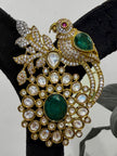 Ornate brooch with parrot design, green stones