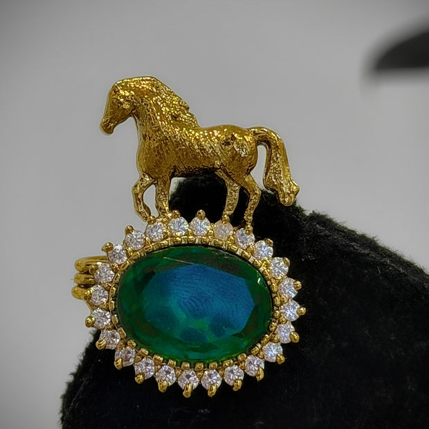 Gold horse pendant with a green gemstone 