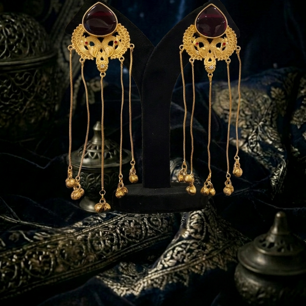 Pair of gold earrings with dark gemstones