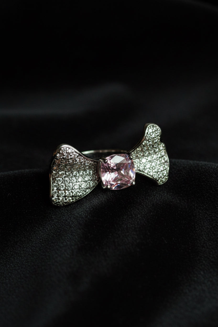 Silver bow-shaped ring with a pink gemstone