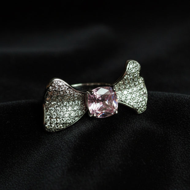 Silver bow-shaped ring with a pink gemstone