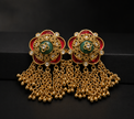 Ornate gold earrings with green 