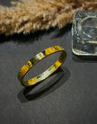 Gold bracelet on a dark surface 