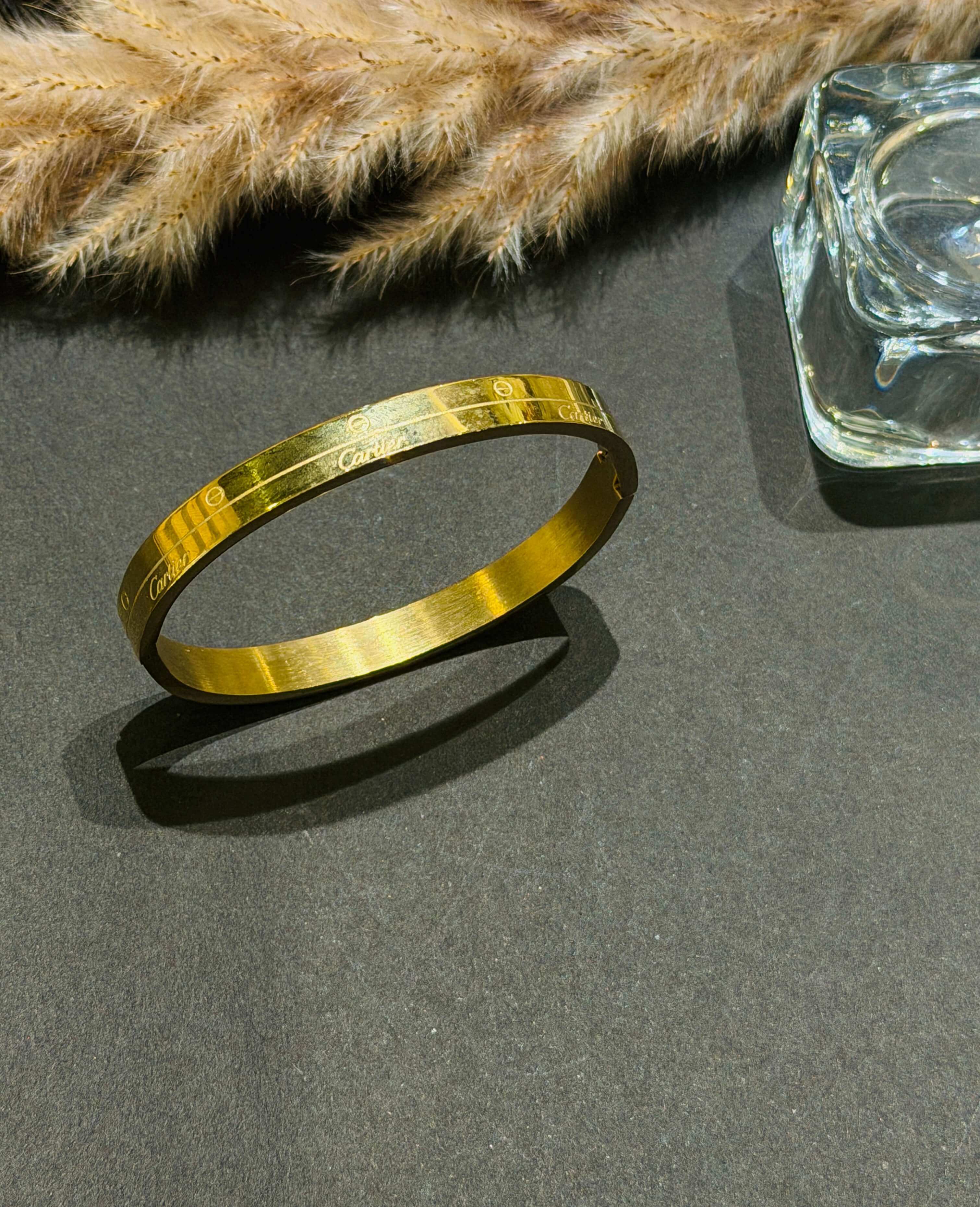 Gold bracelet on a dark surface