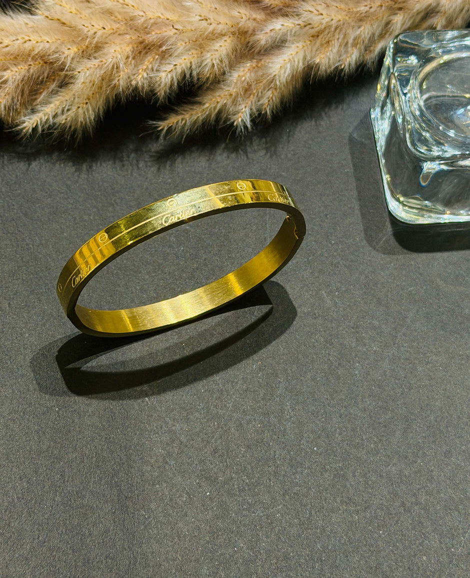 Gold bracelet on a dark surface