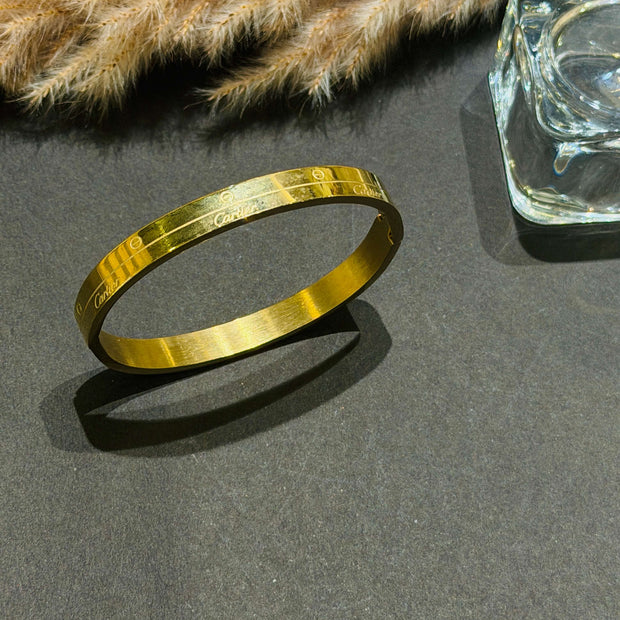 Gold bracelet on a dark surface