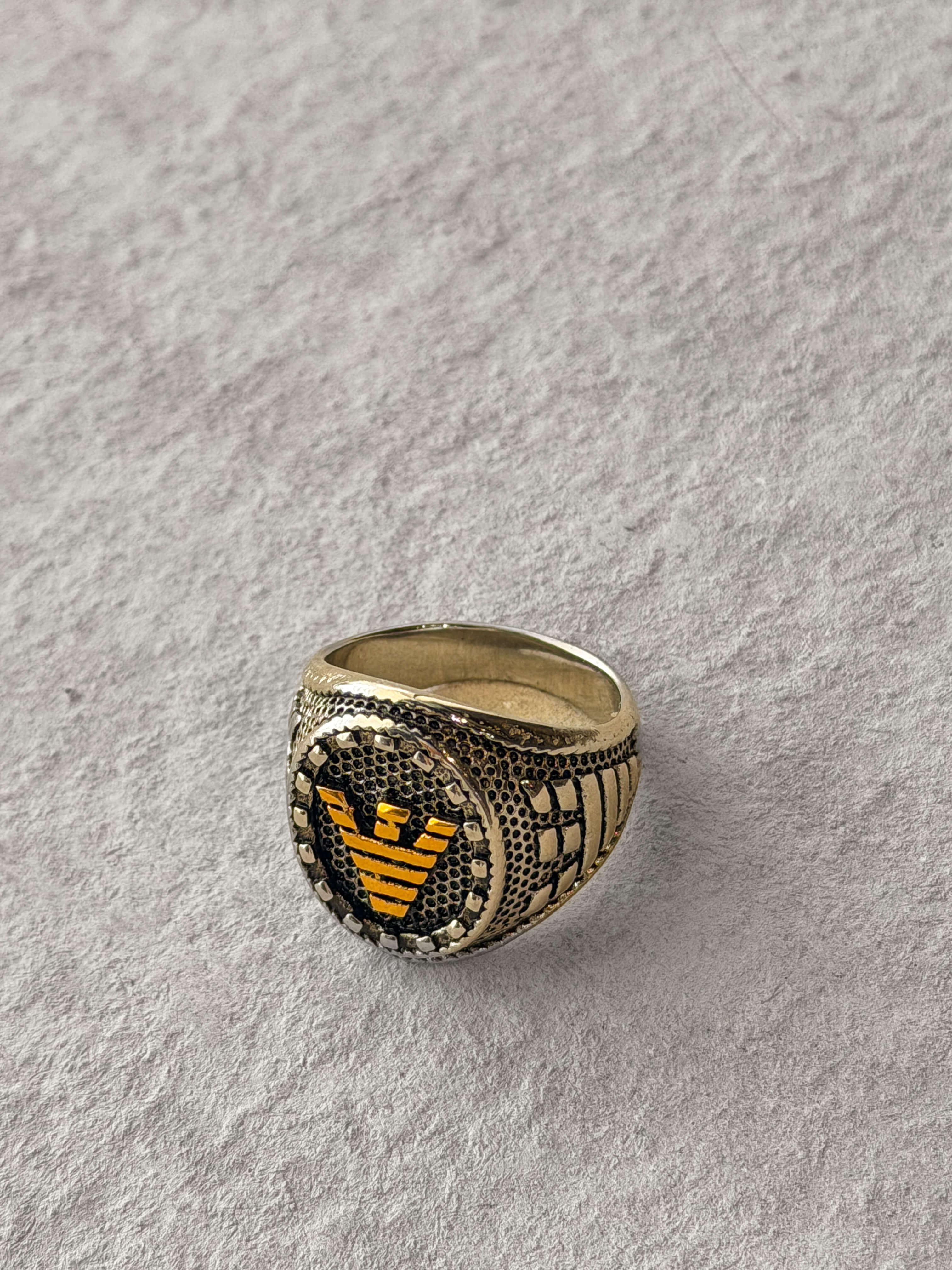 Gold ring with a black and gold emblem 