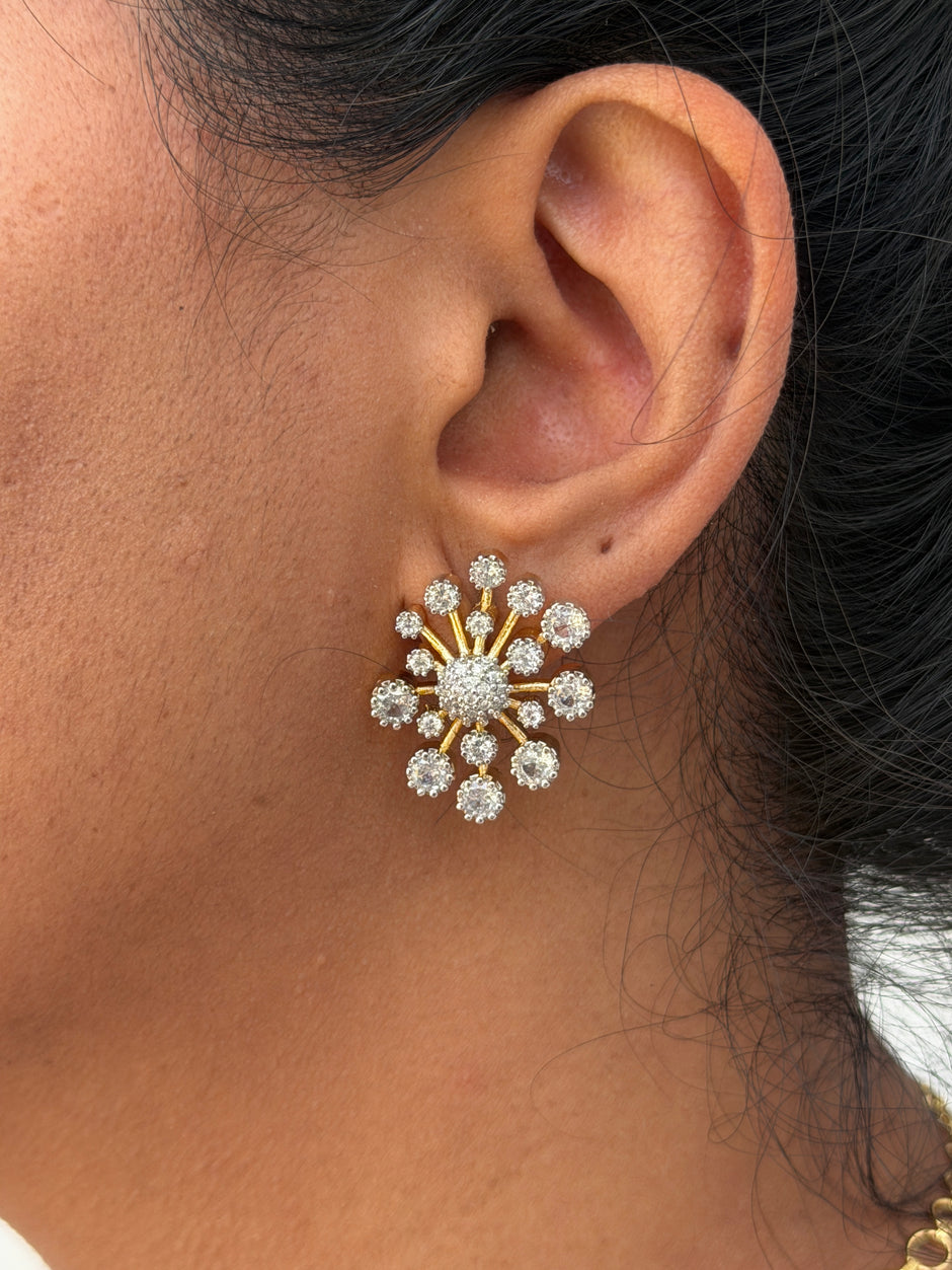 wearing a gold and diamond earring.