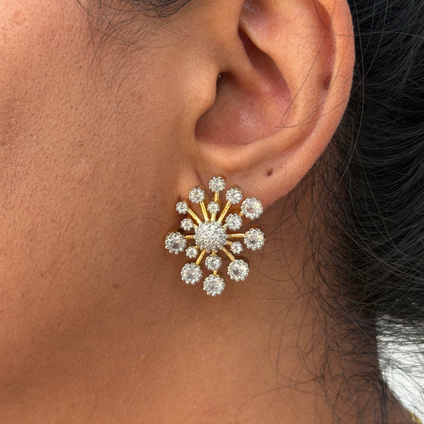 wearing a gold and diamond earring.