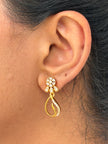 Gold earring worn on an ear 
