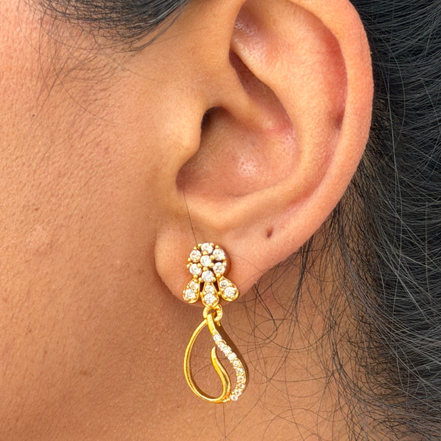 Gold earring worn on an ear 
