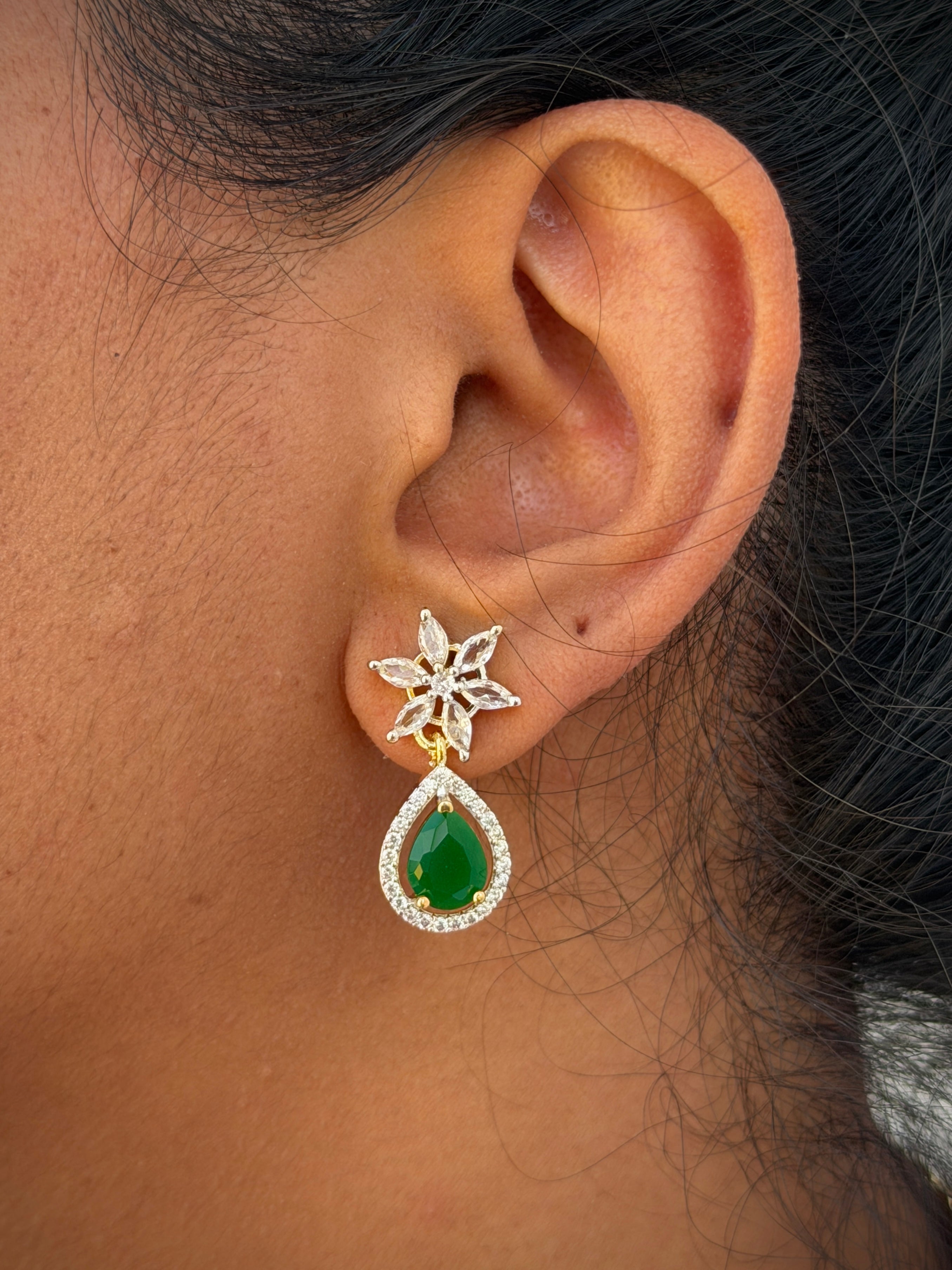  earring with a green teardrop gemstone.