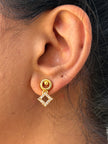 Close-up of an ear wearing a gold earring 