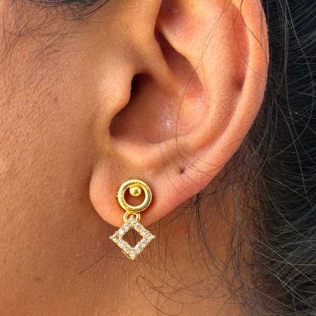 Close-up of an ear wearing a gold earring 