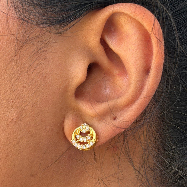 Close-up of an ear wearing a gold earring