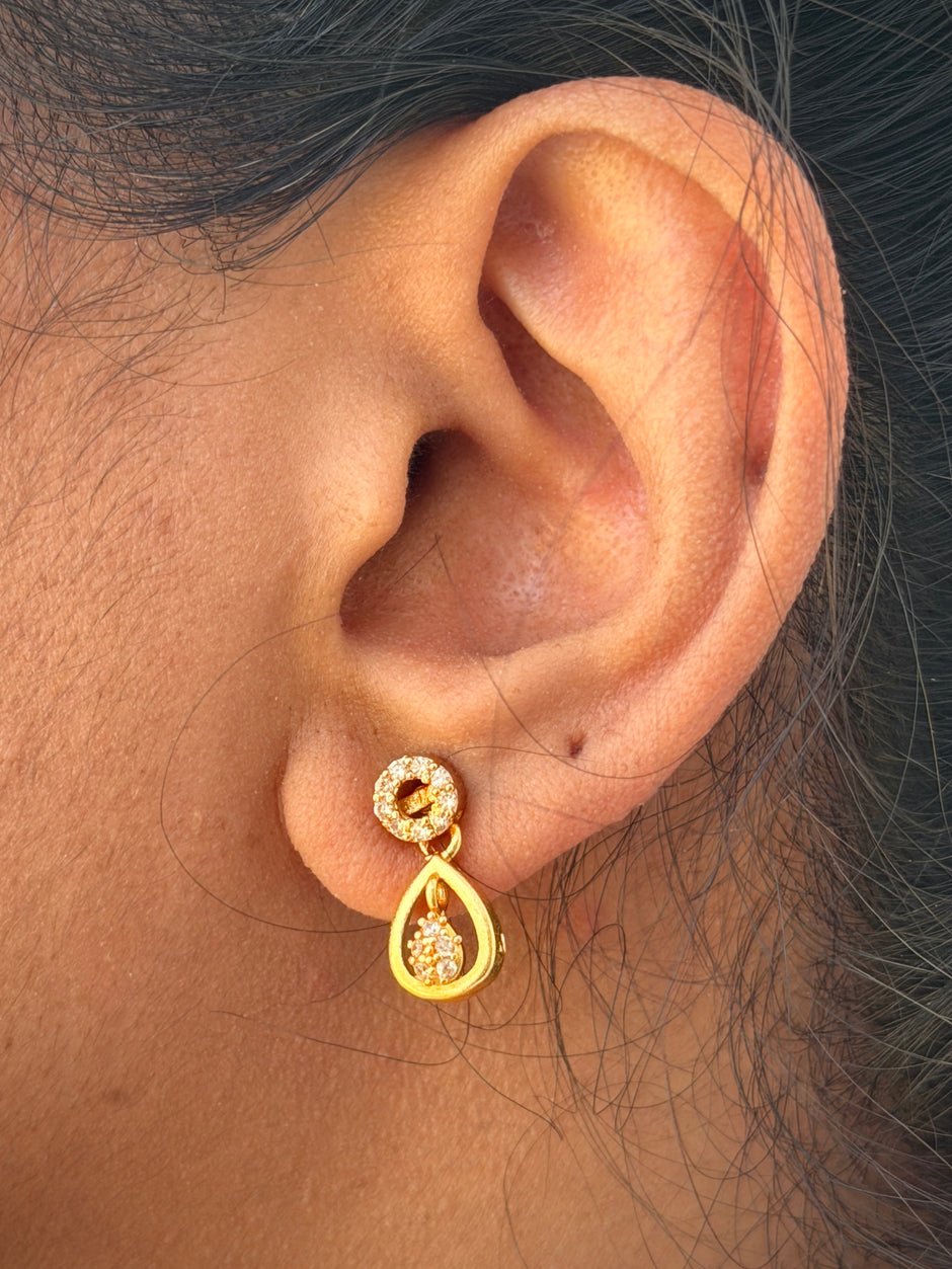 Gold earring worn on an ear 