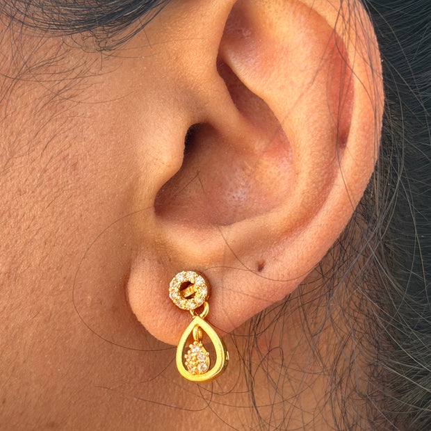 Gold earring worn on an ear 