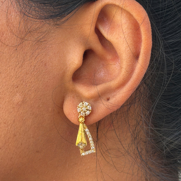 ear wearing a gold and diamond earring