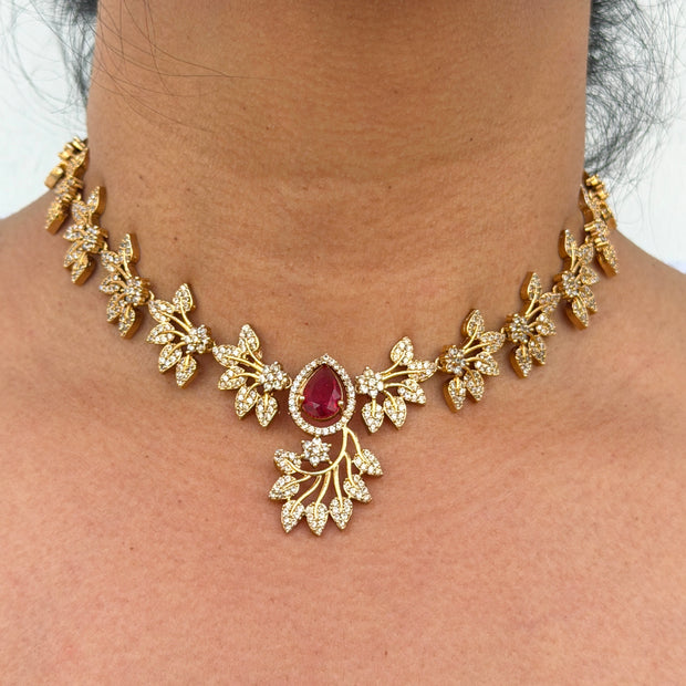 Gold necklace with a red gemstone