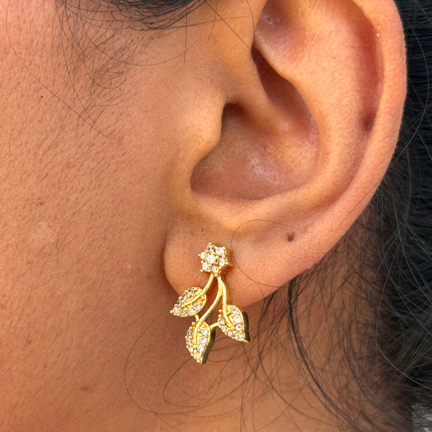 ear wearing a gold earring with leaf design