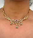 Gold necklace with gemstones on a person's neck