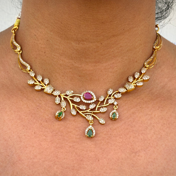 Gold necklace with gemstones on a person's neck