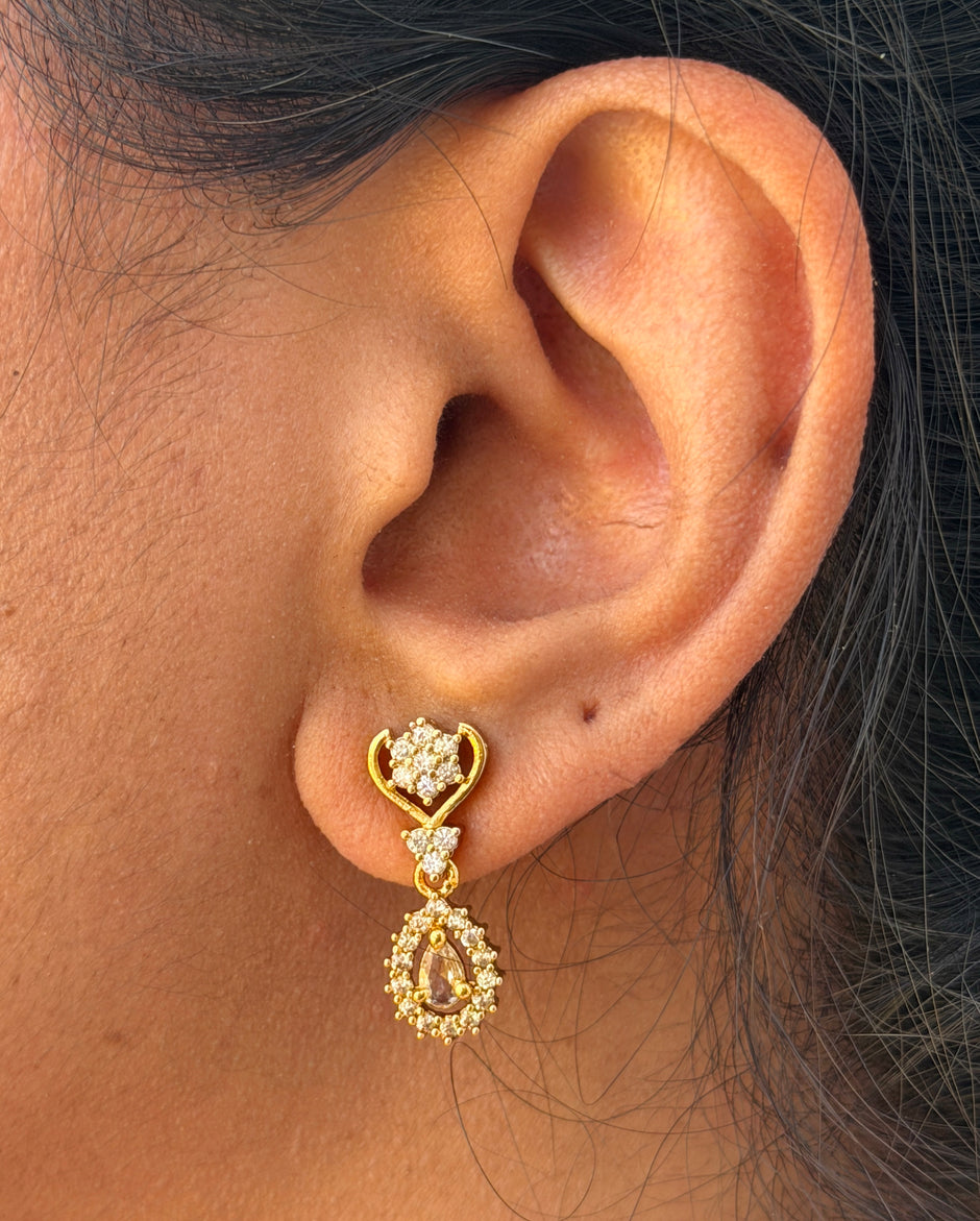 Gold earring with a white gemstone 