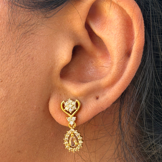Gold earring with a white gemstone 