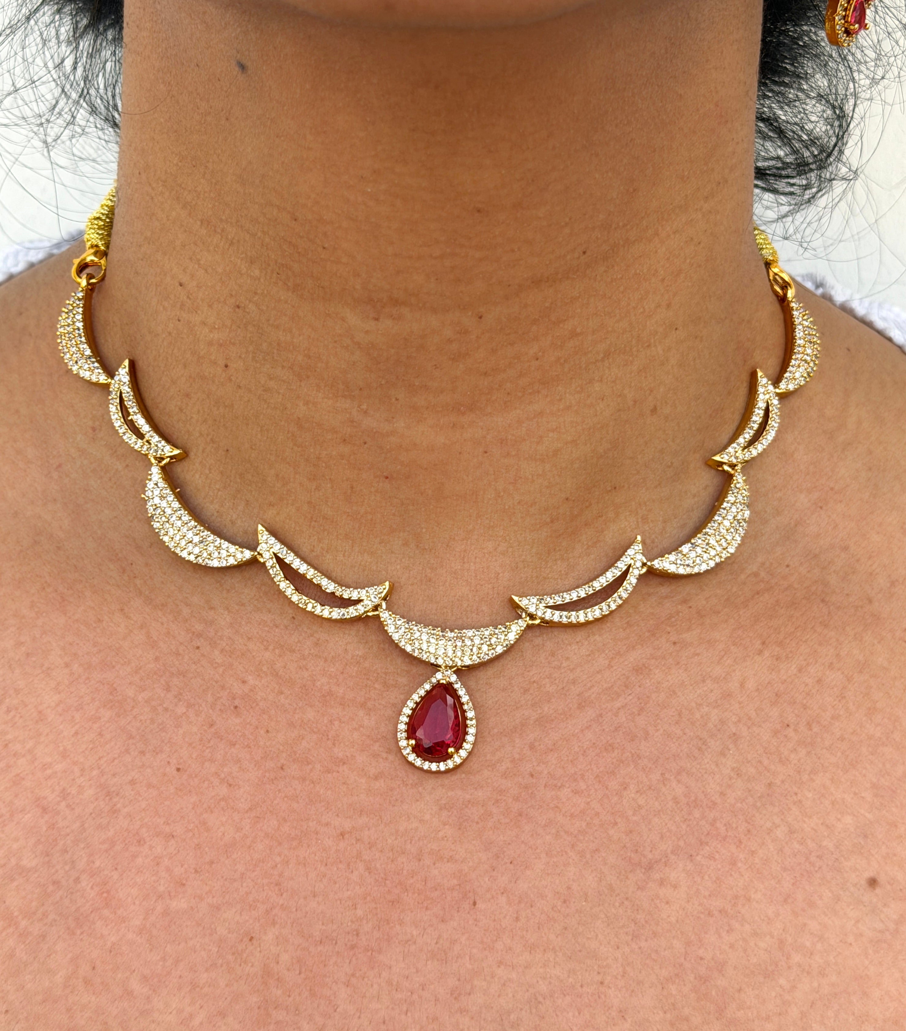 Gold necklace with a red gemstone 