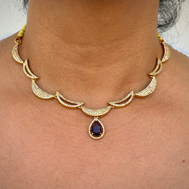 Gold necklace with a central purple gemstone