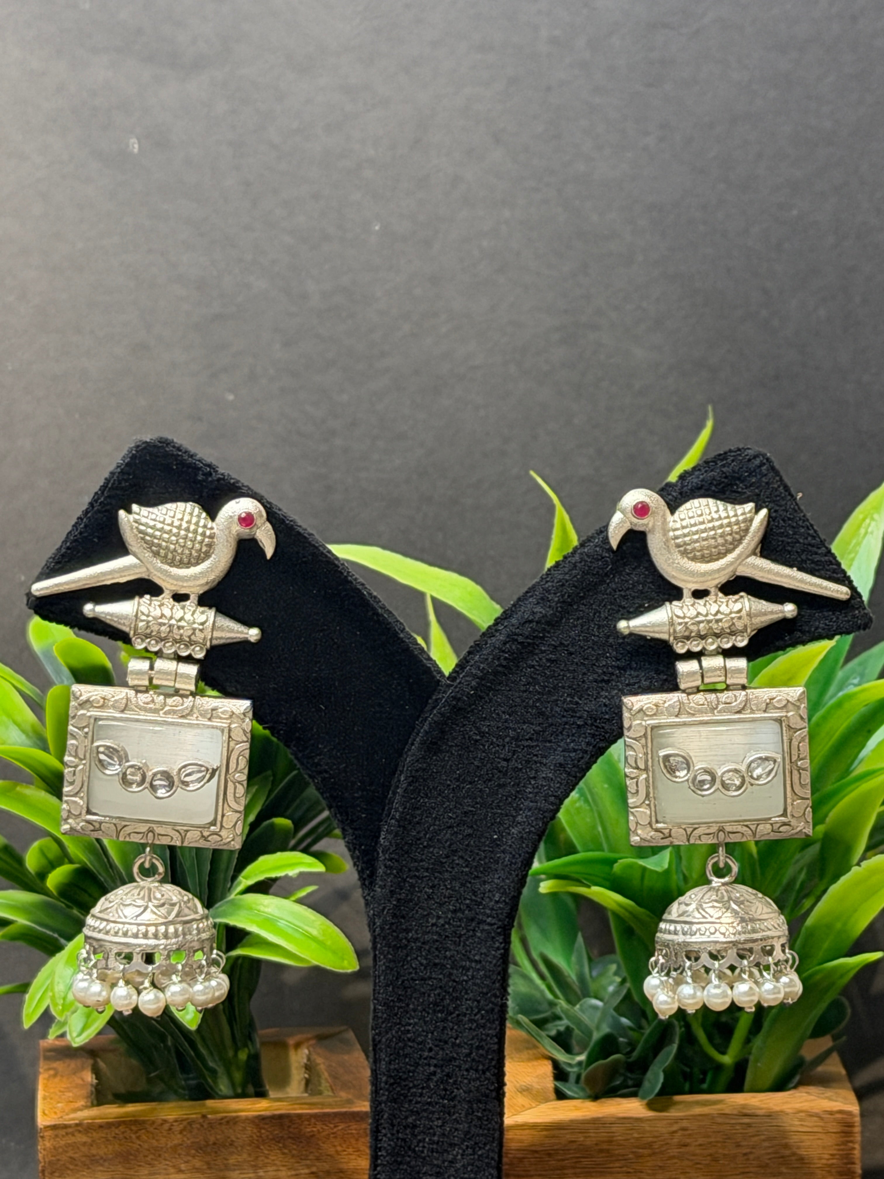 Silver jewelry pieces on a black stand